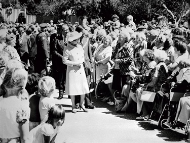 Queen Elizabeth II chats with elderly residents in the Square, , escorted by then-Mayor Brian Elwood and other dignitaries, 26 February 1977.