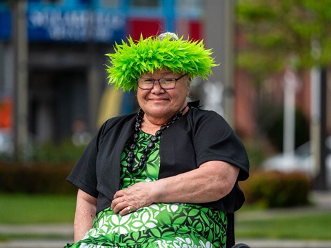 photo shows a woman in green dress sitting on a square