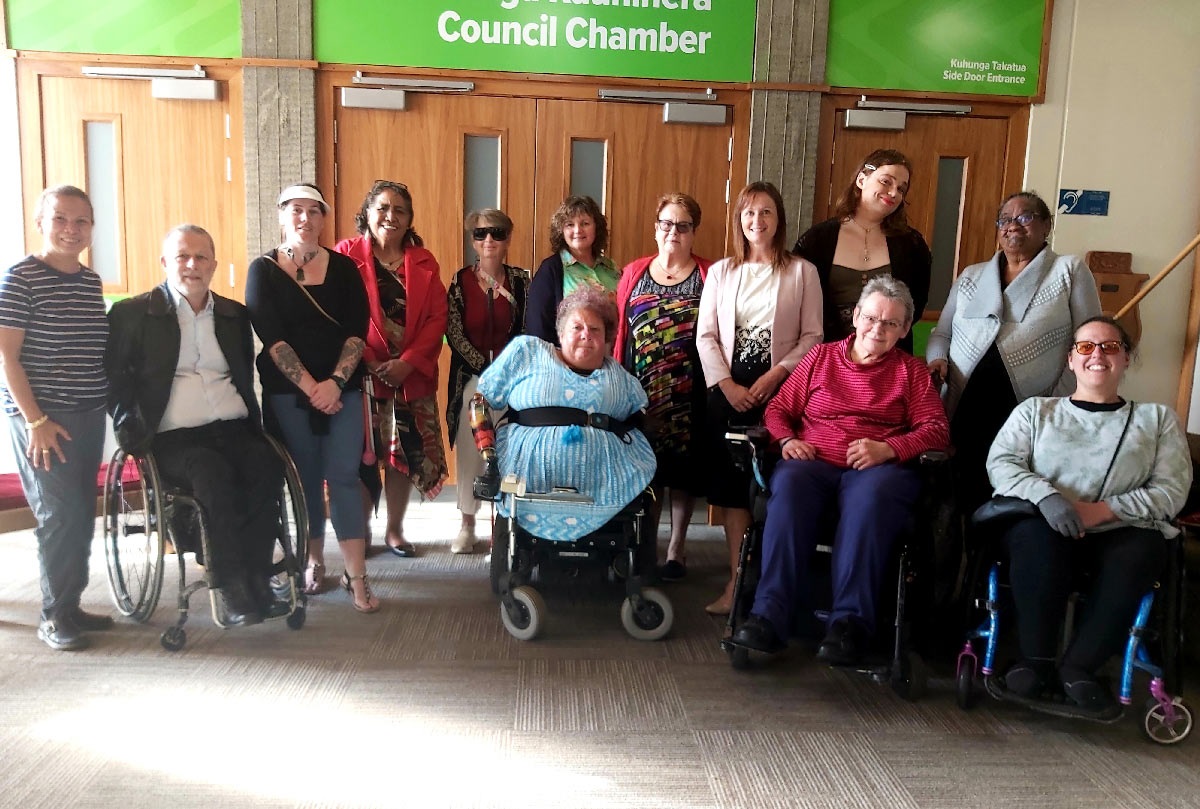 Group photo of disability reference group members in front of the council chamber