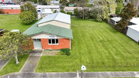 Image shows aerial view of a hall sitting on a section covered by grass