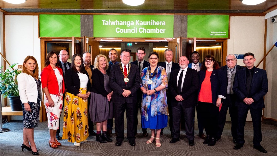 The mayor and councillors standing in front of the Council Chamber.