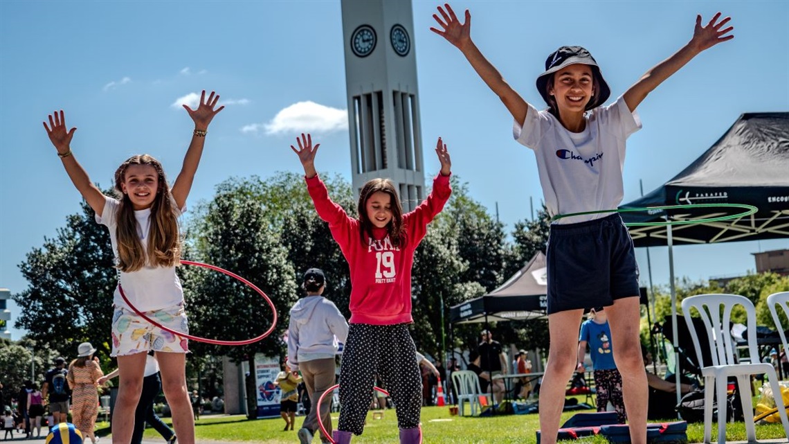 Three girls hula-hooping in Te Marae o Hine at last year's play festival.