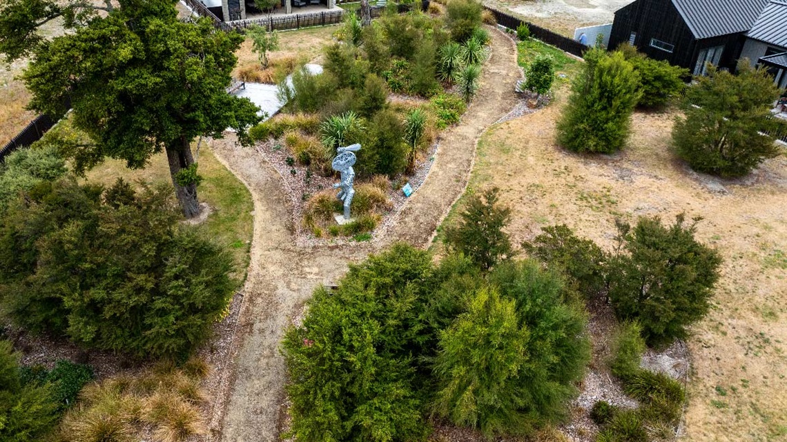 Image shows aerial view of a metal sculpture standing next to pathways