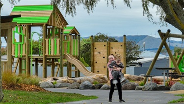 A young girl cuddles her little brother in the playground at Cloverlea Park.