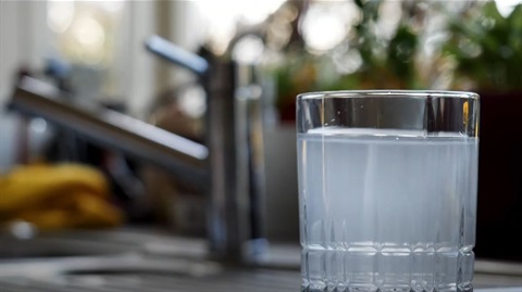 Image shows a glass full of cloudy water by the sink