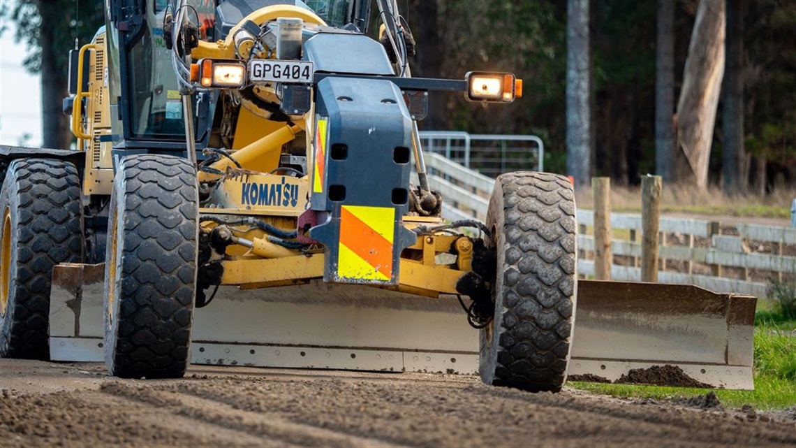 Grader levelling the road surface so it can be resealed.